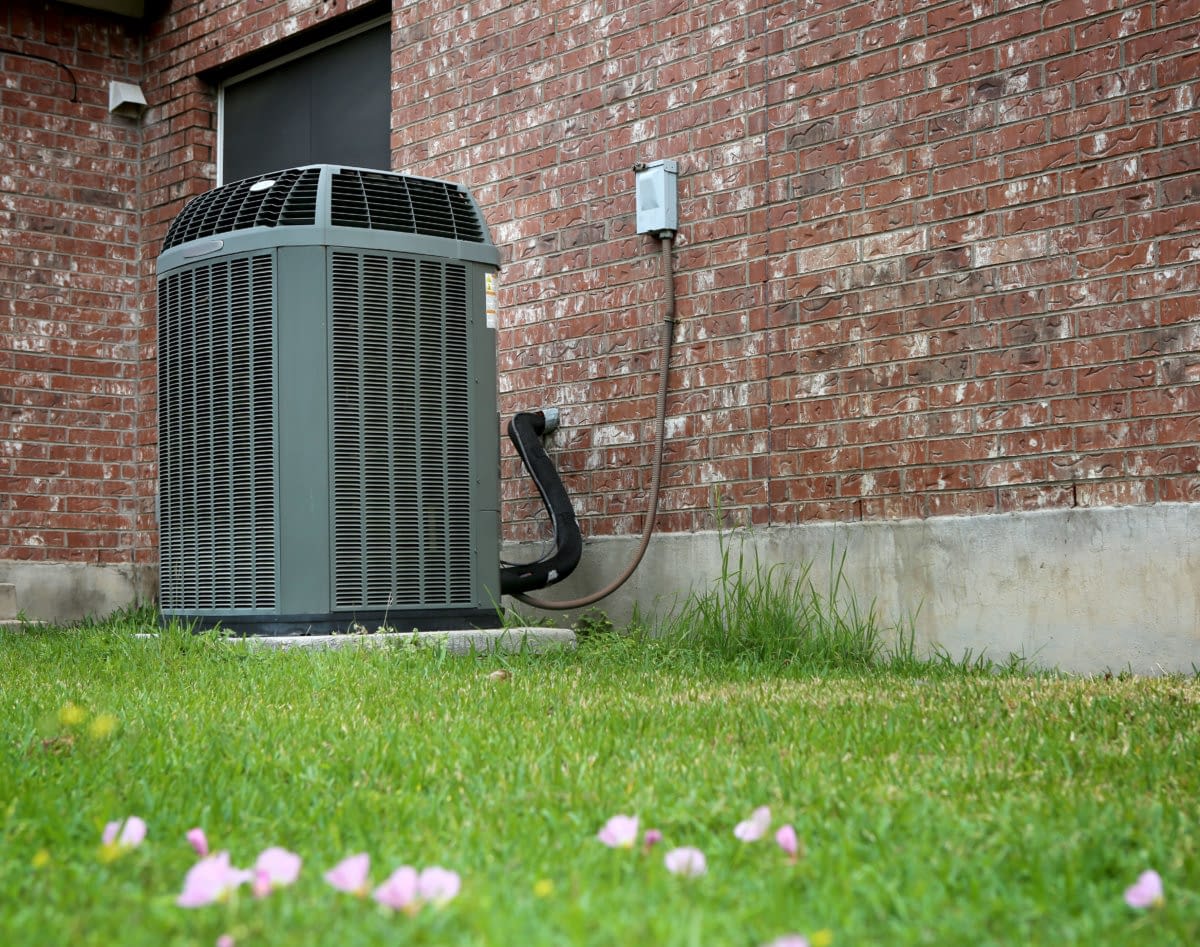 Modern AC heating unit attached to a brick wall